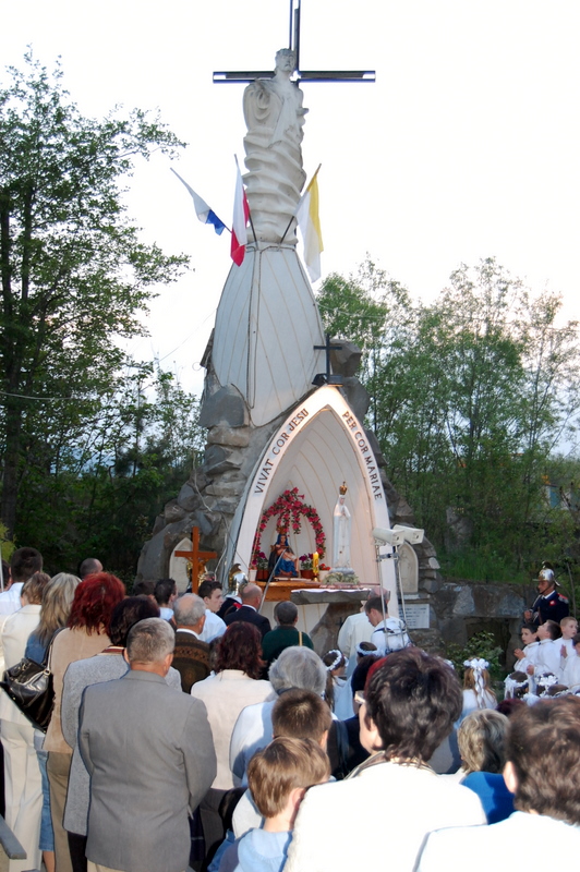 Grupa ludzi modlących się przed makietą grobu Jezusa Chrystusa