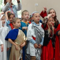 Dzieci przebrane za postacie biblijne ustawione w rzędzie pozują do zdjęcia