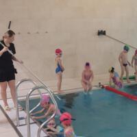 Uczestnicy projektu - dzieci - na basenie uczą się pływać