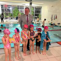 Uczestnicy projektu - dzieci - na basenie - wójt gminy wręcza medale - dzieci w strojach kąpielowych - wójt w garniturze