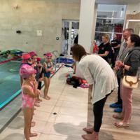Uczestnicy projektu - dzieci - na basenie - wójt gminy wręcza medale - dzieci w strojach kąpielowych - wójt w garniturze