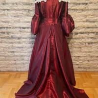 Elegancka suknia wieczorowa w kolorze bordowym umieszczona manekinie - bogato zdobiona koronkami