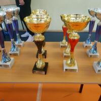 Puchary dla zwycięskich drużyn ustawione na stoliku