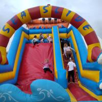 Festiwal radości - dzieci uczestniczą w rożnych grach i zabawach na boisku na świeżym powietrzu, dmuchańce, autka elektryczne, popcorn - zdjęcia ilustracyjne