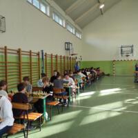 Zawodnicy grają w szachy na sali gimnastycznej