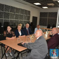 Na sali przy stołach siedzi 7 osób - są to radni i sołtysi, na ścianie godło polski i herb gminy
