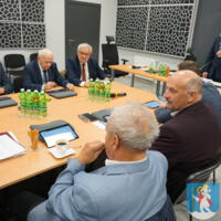 Sesja Rady Gminy Chełmiec - radni siedzą przy stole na sali posiedzeń