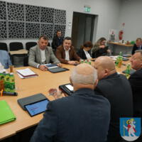 Sesja Rady Gminy Chełmiec - radni siedzą przy stole na sali posiedzeń