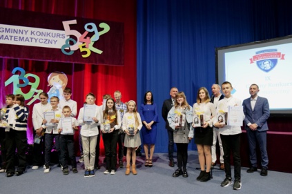 Wspólne zdjęcie uczestników konkursu z dyplomami, wśród nich wójt gminy i dyrektor szkoły oraz nauczyciele